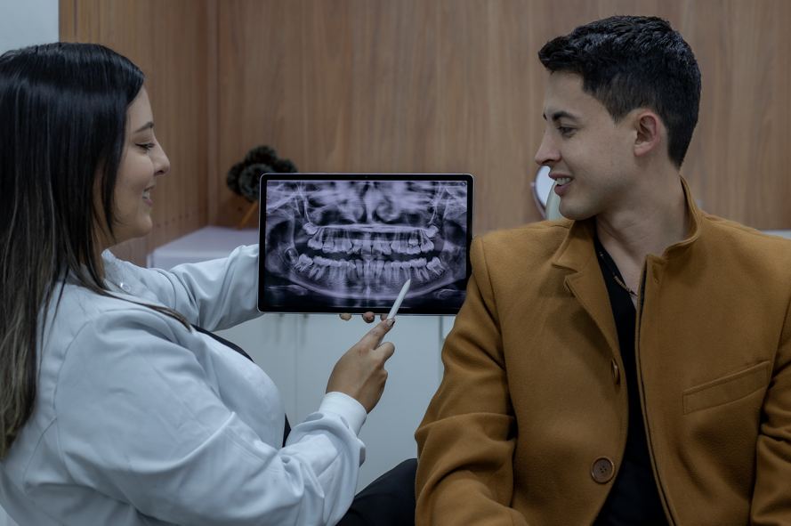 Doctor de Oral Dent revisando una radiografía junto a su paciente